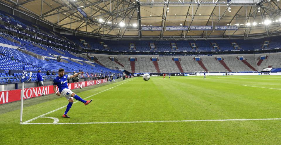 FILE - In this May 24, 2020, file photo, Schalke's Daniel Caligiuri kicks the ball in front of empty seats during the German Bundesliga soccer match between FC Schalke 04 and FC Augsburg at the Veltins-Arena in Gelsenkirchen, Germany. (AP Photo/Martin Meissner, Pool, File)