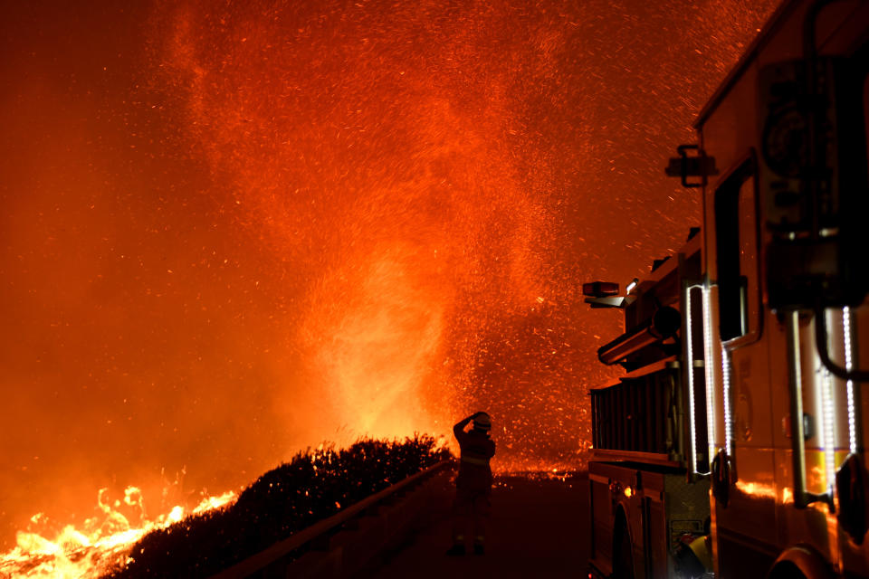 <p>A fire tornado churns near an overpass above the 101 freeway on December 6 in Ventura, California.</p>