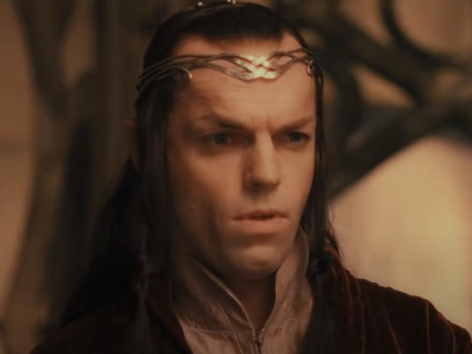 Lord Elrond wearing a black jacket and gold crown in lord of the rings