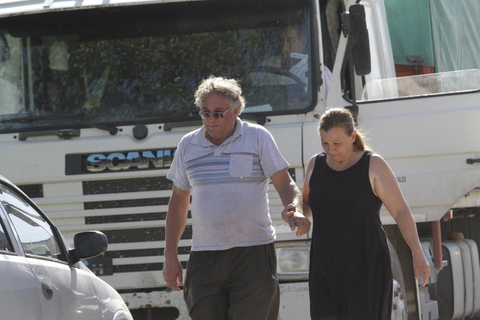 CORRECTS NAME OF PARTNER - Horacio Sala, father of Argentine soccer player Emiliano Sala, holds hands with his partner Liliana Ponce outside their home in Progreso, Argentina, Tuesday, Jan. 22, 2019. The French civil aviation authority says the 28-year-old Argentine striker was aboard a small passenger plane that went missing off the coast of the island of Guernsey on Monday. "I don't know what to think. ... The hours pass and I am just beginning to think the worst," Sala told media gathered outside the family home. (AP Photo/Mauricio Garin)