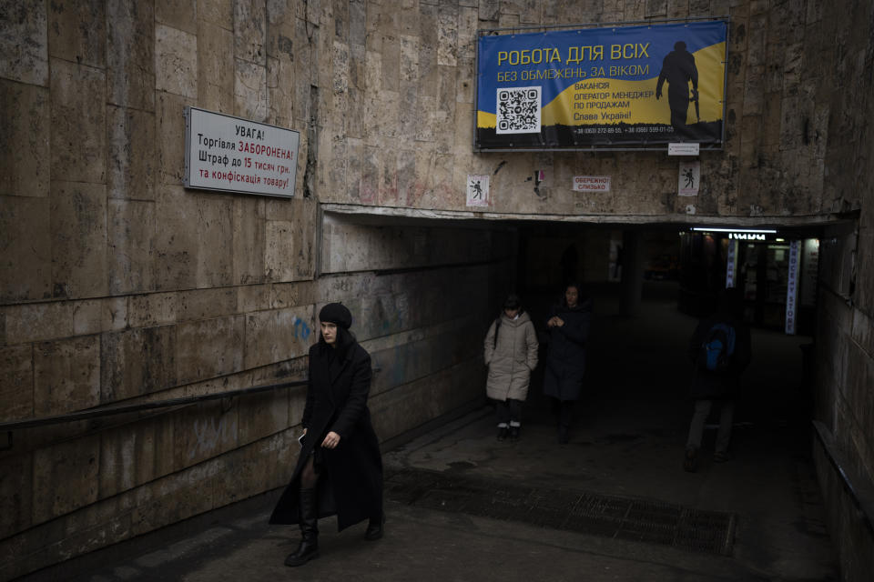 People exit a metro station in Kyiv, Ukraine, Monday, Jan. 30, 2023. (AP Photo/Daniel Cole)