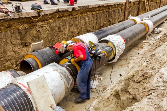 person working on constructing a pipeline