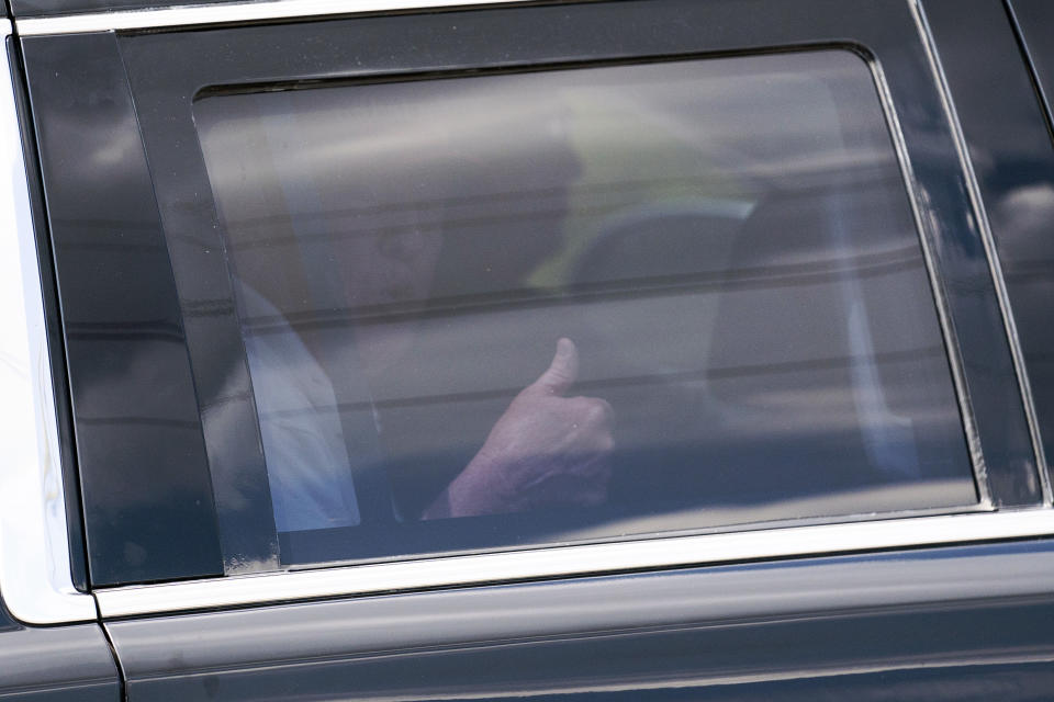 A motorcade carrying former President Donald Trump gives a thumbs up as he leaves Trump International Golf Club, Sunday, April 2, 2023, in West Palm Beach, Fla. (AP Photo/Evan Vucci)