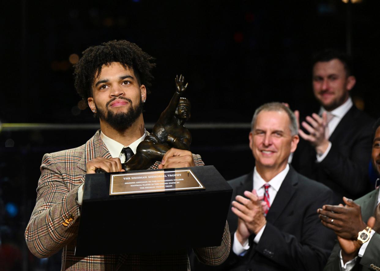 Southern California quarterback Caleb Williams lifts the Heisman Trophy.