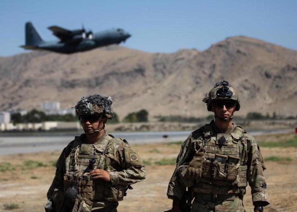 Two Paratroopers assigned to the 1st Brigade Combat Team, 82nd Airborne Division conduct security while a C-130 Hercules takes off during a non-combatant evacuation operation Aug. 25, 2021, in Kabul, Afghanistan.