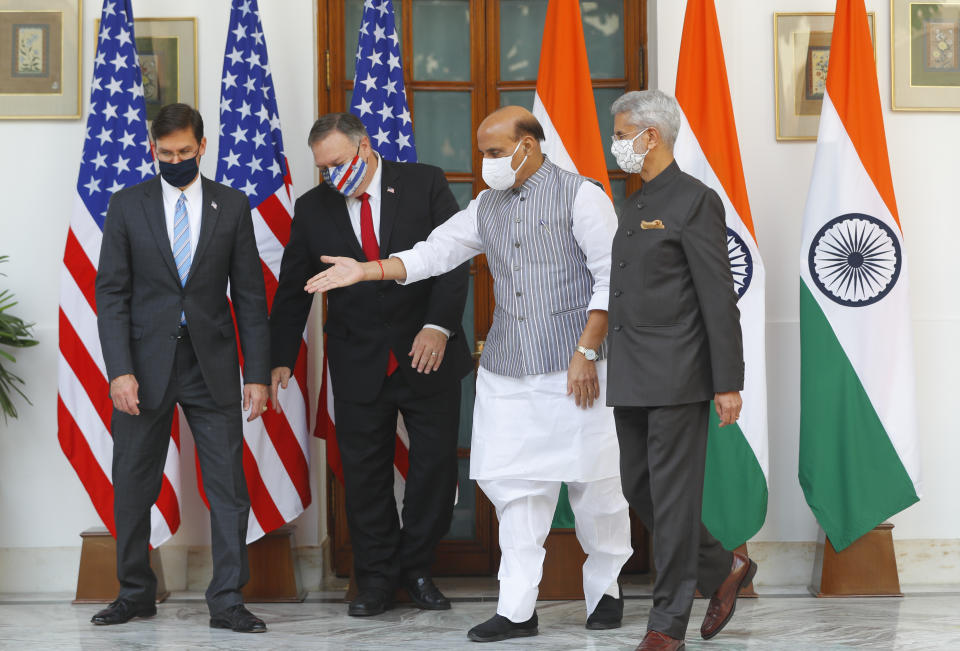 Indian Defence Minister Rajnath Singh, second right, gestures towards U.S. Secretary of State Mike Pompeo, second left, and Secretary of Defence Mark Esper, left, with Indian Foreign Minister Subrahmanyam Jaishankar, right, standing beside him, ahead of their meeting at Hyderabad House in New Delhi, India, Tuesday, Oct. 27, 2020. In talks on Tuesday with their Indian counterparts, Pompeo and Esper are to sign an agreement expanding military satellite information sharing and highlight strategic cooperation between Washington and New Delhi with an eye toward countering China. (Adnan Abidi/Pool via AP)