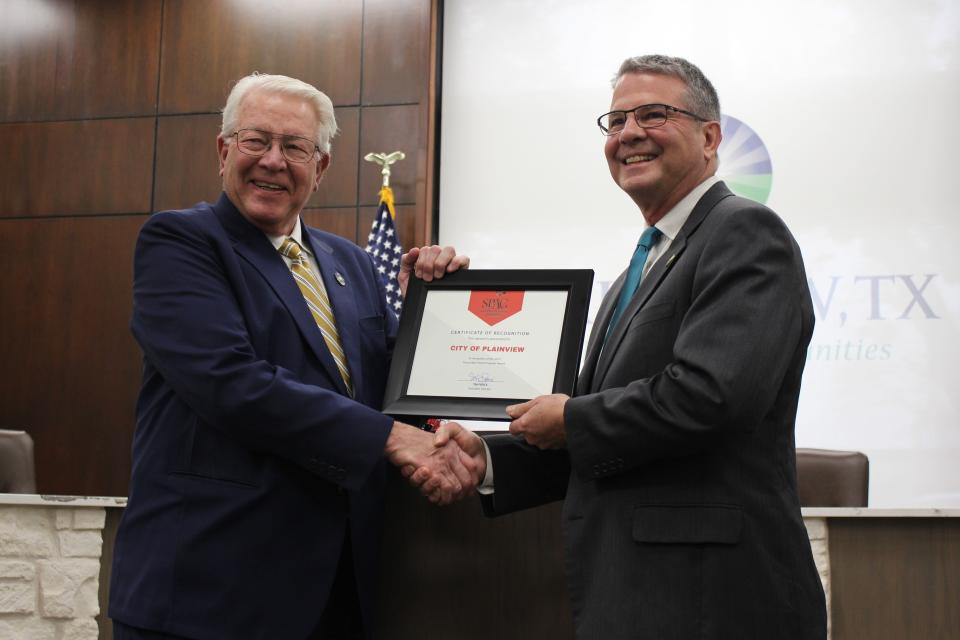 State Sen. Charles Perry, right, presents a $500,000 grant to Plainview Mayor Charles Starnes Tuesday at City Hall.