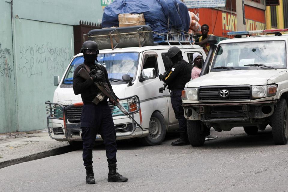 PHOTO: A police officer stands at a checkpoint on the street, as another inspects passing cars to ensure no one carries weapons, in Port-au-Prince, Haiti, on May 24, 2024.  (Ralph Tedy Erol/Reuters)