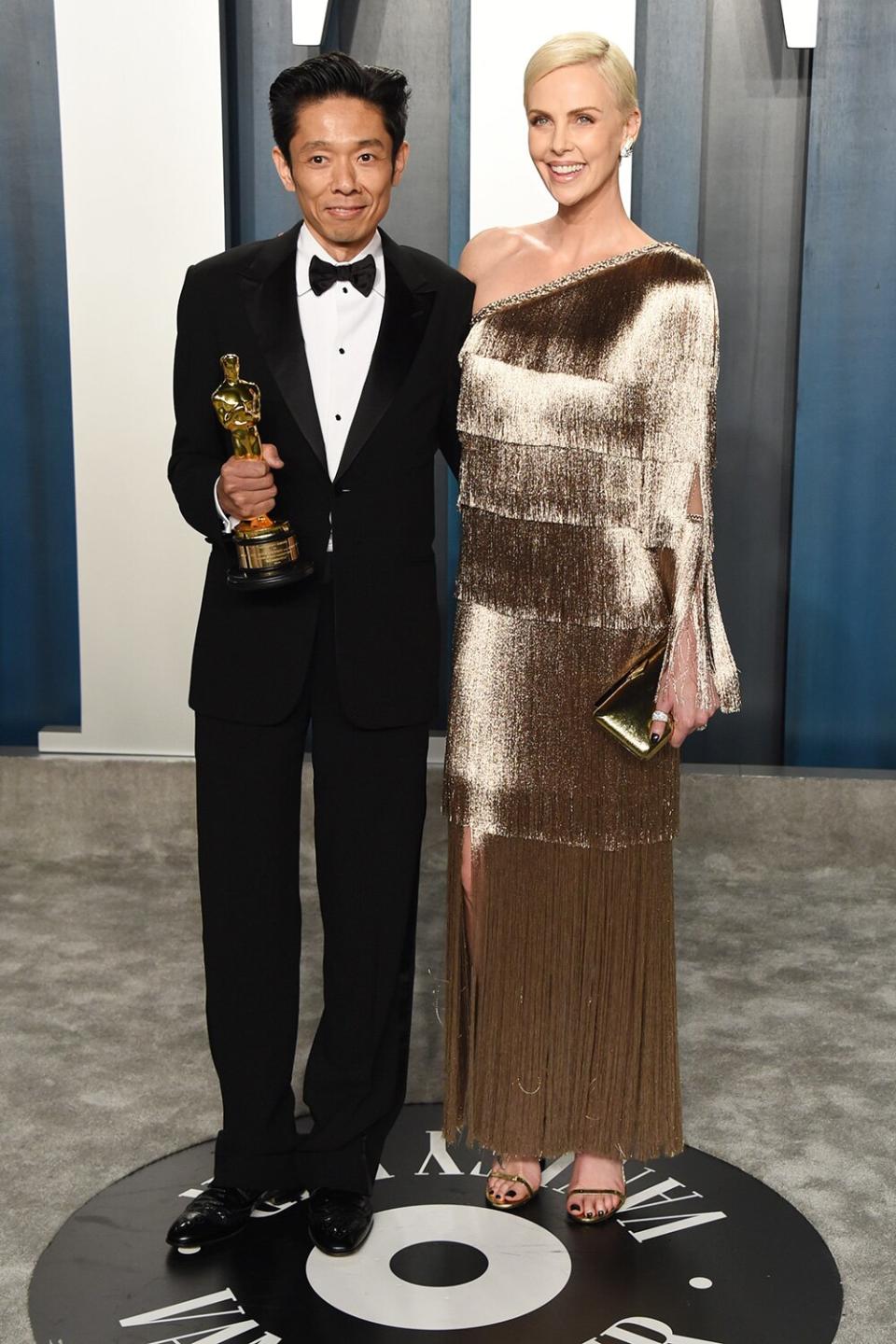 Charlize Theron and Kazuhiro Tsuji, the special effects artist responsible for her <em>Bombshell </em>transformation, pose at the 2020 Vanity Fair Oscar Party. 