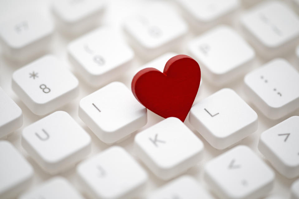 Small red heart on computer keyboard. Internet dating concept.