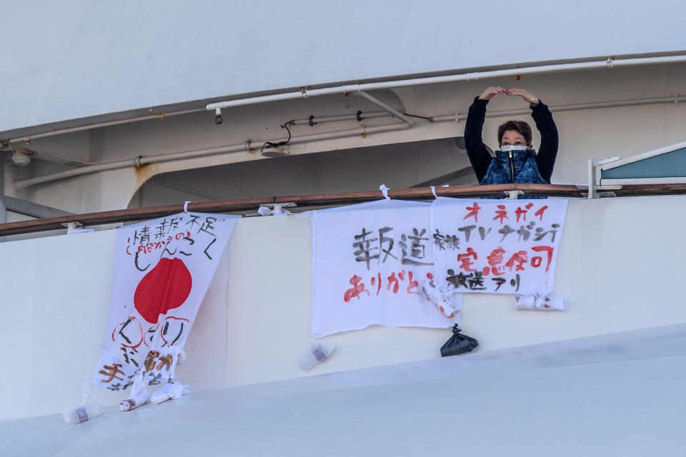 Due to the novel coronavirus, thousands of passengers remain quarantined aboard the Diamond Princess, which is docked in Yokohama, Japan. According to Getty Images, the banners are asking for the situation to be broadcast on TV, and indicate a shortage of medication on the ship. (Photo: Getty Images)