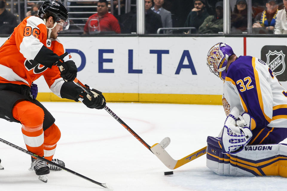 Los Angeles Kings goalie Jonathan Quick, right, stops a shot bt Philadelphia Flyers forward Joel Farabee during the first period of an NHL hockey game Saturday, Dec. 31, 2022, in Los Angeles. (AP Photo/Ringo H.W. Chiu)