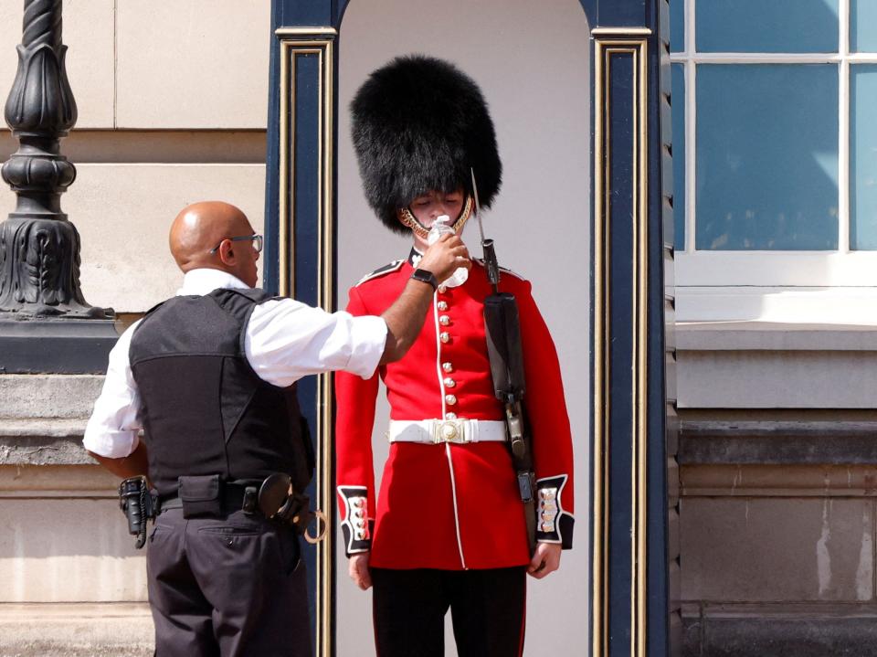 A member of the Queen's Guard receives water to drink during the hot weather (John Sibley/Reuters)