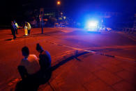 People sit by the side of the road next to a police cordon outside the Manchester Arena, where U.S. singer Ariana Grande had been performing, in Manchester, northern England, Britain, May 23, 2017. REUTERS/Andrew Yates