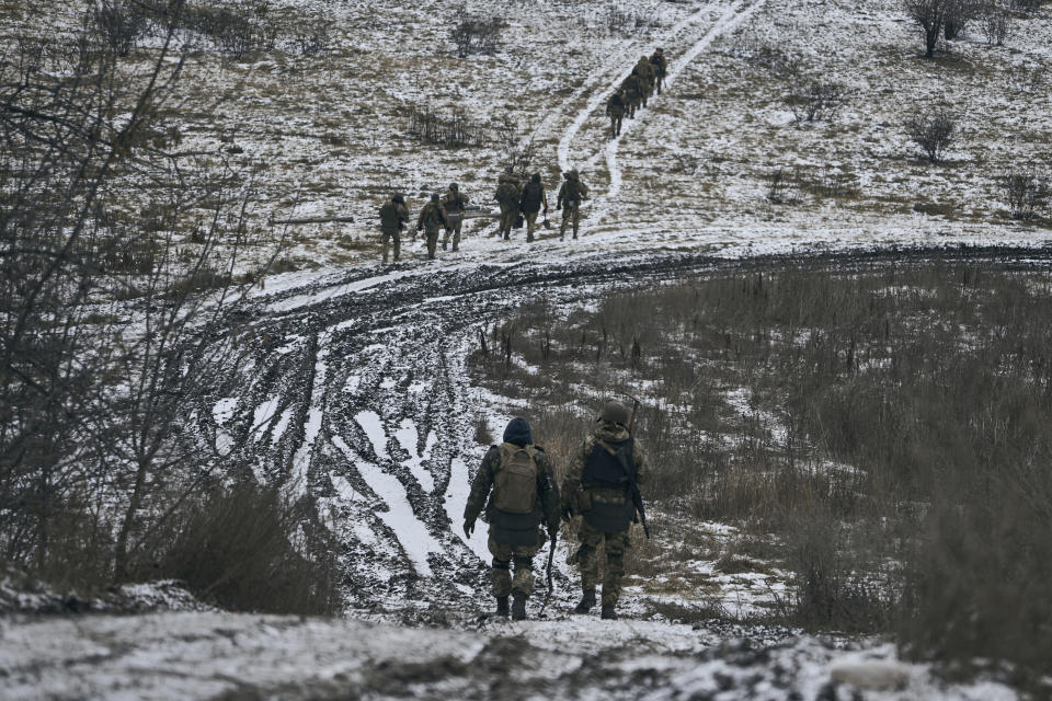 Ukrainian soldiers walk in the position close to Bakhmut, Ukraine, Thursday, Jan. 12, 2023. (AP Photo/LIBKOS)