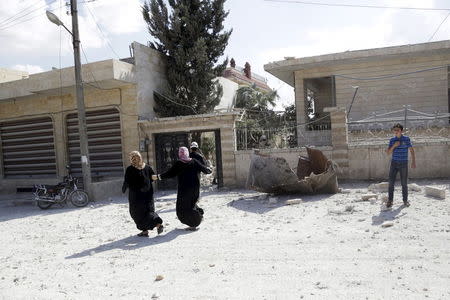 Women run at a site hit by what activists said were airstrikes carried out by the Russian air force in Kafranbel, near Idlib Syria October 10, 2015. REUTERS/Khalil Ashawi