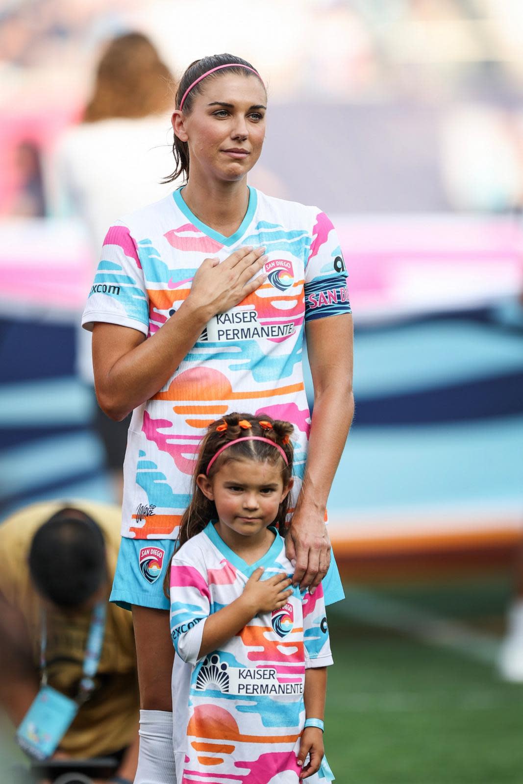 PHOTO: Alex Morgan of San Diego Wave FC stands with her daughter, Charlie during the national anthem before playing the last match of her career Sept. 8, 2024, in San Diego. (Meg Oliphant/Getty Images)