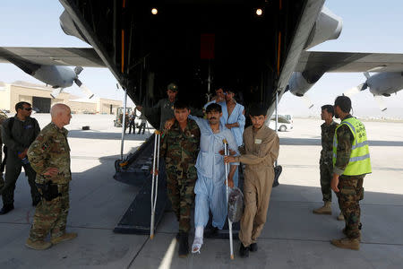 Afghan Air Force medical personnel help an injured member of the Afghan security forces to get off a C-130 military transport plane in Kabul, Afghanistan July 9, 2017. REUTERS/Omar Sobhani