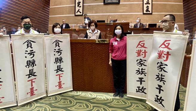 民進黨宜蘭縣黨團拿「貪汙縣長下台」、「反對家族干政」的卷軸，一行人無聲抗議站主席台2側。（吳佩蓉攝）