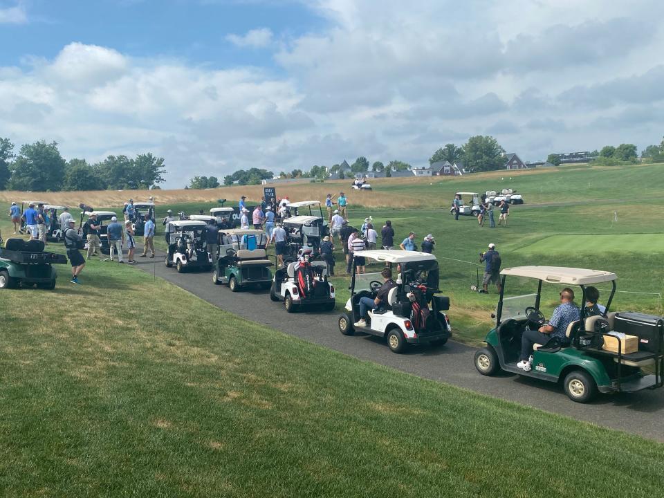 A long line of golf carts follows as former President Trump plays his round.
