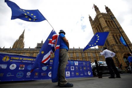 FILE PHOTO: Anti-Brexit demonstrators wave EU and Union flags opposite the Houses of Parliament, in London, Britain, June 19, 2018. REUTERS/Henry Nicholls