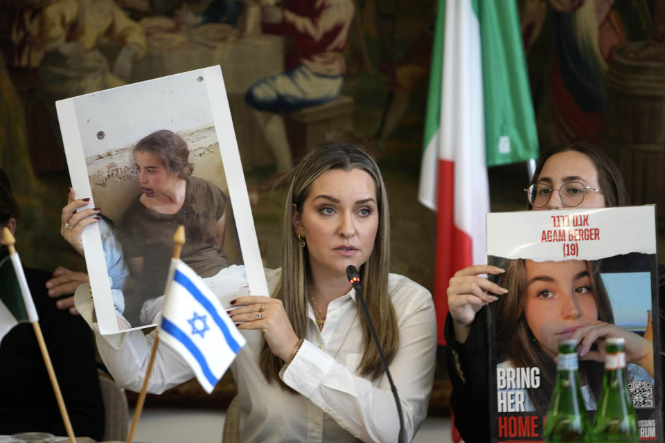 Ashley Waxman Bakshi, left, shows a photo of her cousin Agam Berger, one of the hostages being held by Hamas, flanked by Agam's sister, Li-Yam Berger, during a press conference in Rome, Monday, April 8, 2024. Pope Francis met Monday with relatives of hostages taken by Hamas on Oct. 7, marking the six-month anniversary of the attack in southern Israel with an hourlong audience. (AP Photo/Alessandra Tarantino)