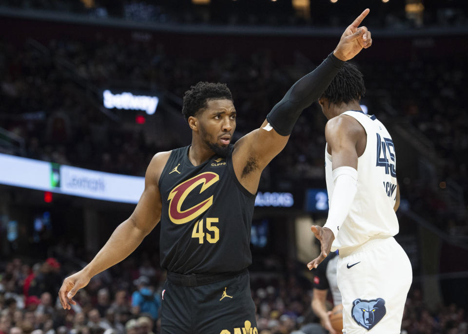 Cleveland Cavaliers' Donovan Mitchell (45) directs his team as Memphis Grizzlies' GG Jackson (45) stands by during the first half of an NBA basketball game in Cleveland, Wednesday, April 10, 2024. (AP Photo/Phil Long)