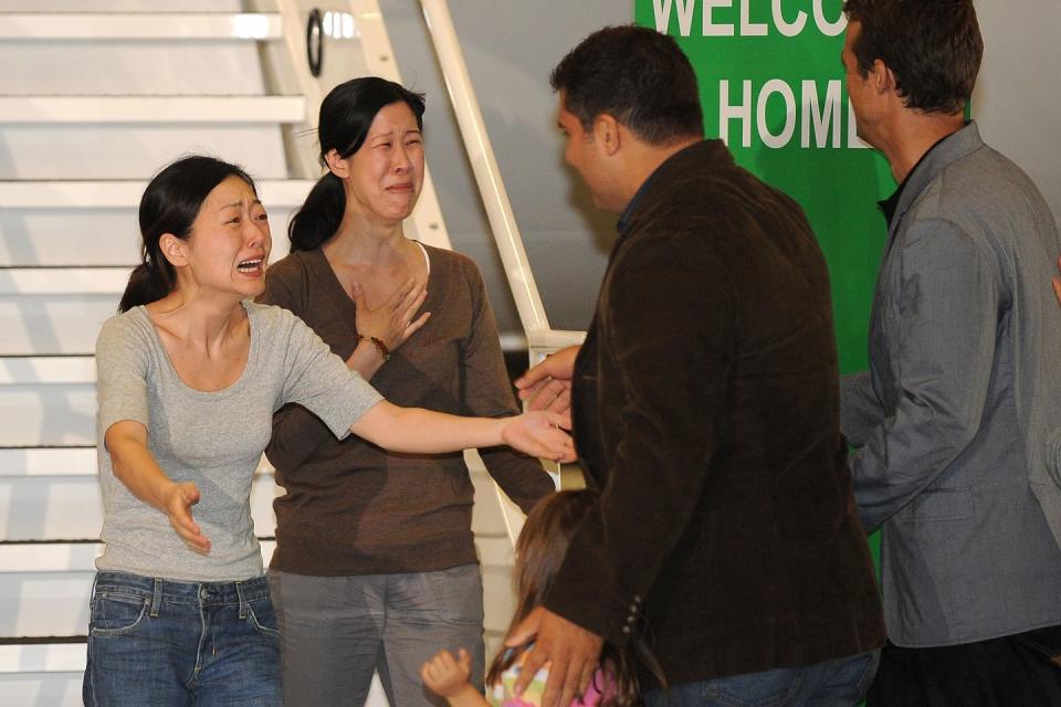 <p>Journalist Euna Lee (left) embraces her husband Michael Saldate (far right) and daughter Hana, while fellow journalist Laura Ling (second from left) greets husband Iain Clayton after being released from North Korea. Following talks in Pyongyang with former U.S. president Bill Clinton, North Korean leader Kim Jong Il pardoned Lee and Ling, who had been sentenced to hard labor for entering the country illegally. </p>