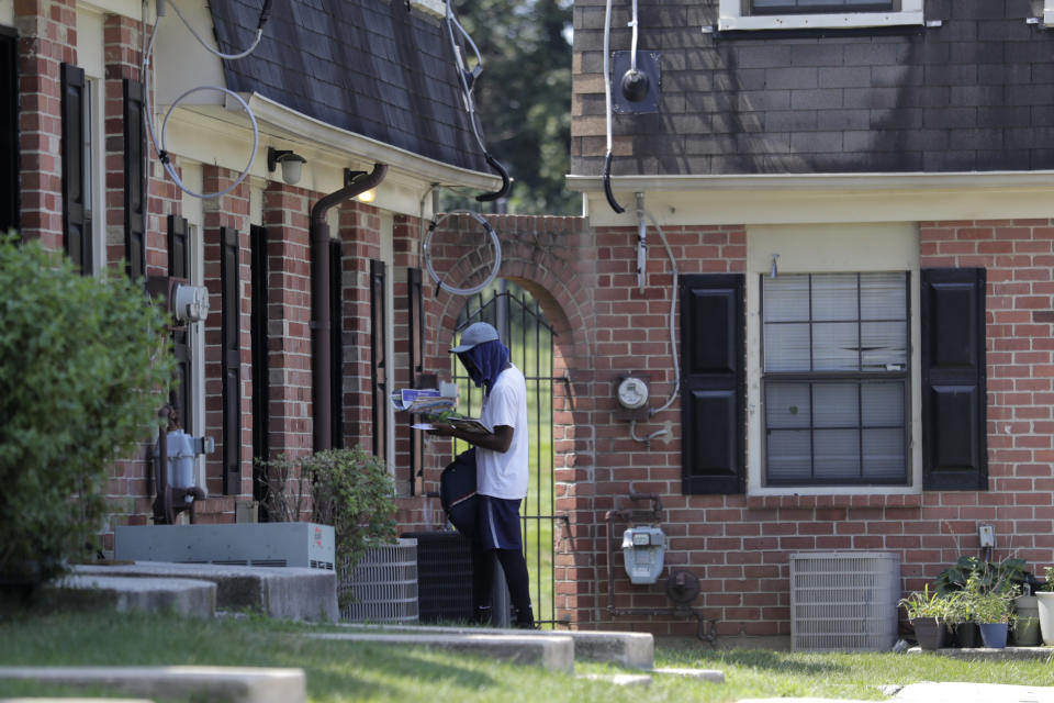 A mail carrier delivers mail at a home at the Dutch Village apartments, Tuesday, July 30, 2019, in Baltimore. The apartment complex is owned by Jared Kushner, son-in-law of President Donald Trump, who days earlier vilified Congressman Elijah Cummings' majority-black Baltimore district as a "disgusting, rat and rodent infested mess" where "no human being would want to live." (AP Photo/Julio Cortez)