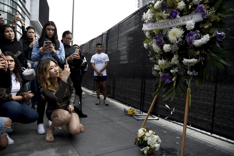 A group of fans gather near a makeshift memorial for NBA legend Kobe Bryant outside the Staples Center in Los Angeles, just before the Grammy Awards were set to take place on Jan. 26, 2020. (AP Foto/Chris Pizzello)