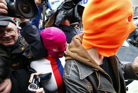 Journalists surround masked members of protest band Pussy Rot leaving a police station in Adler during the 2014 Sochi Winter Olympics, February 18, 2014. REUTERS/Shamil Zhumatov