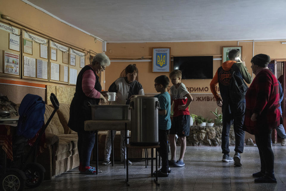 Volunteers provide food to children who were evacuated from the front lines at a shelter for displaced people in Kharkiv, Ukraine, on Monday, April 15, 2024. (AP Photo/Evgeniy Maloletka)