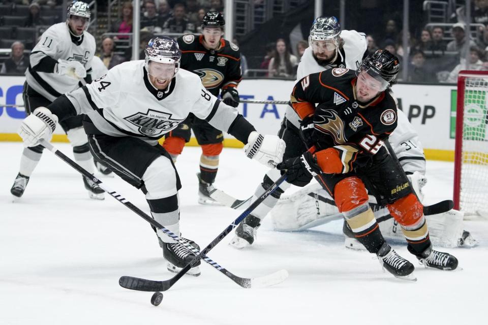 Vladislav Gavrikov battles Mason McTavish for the puck.