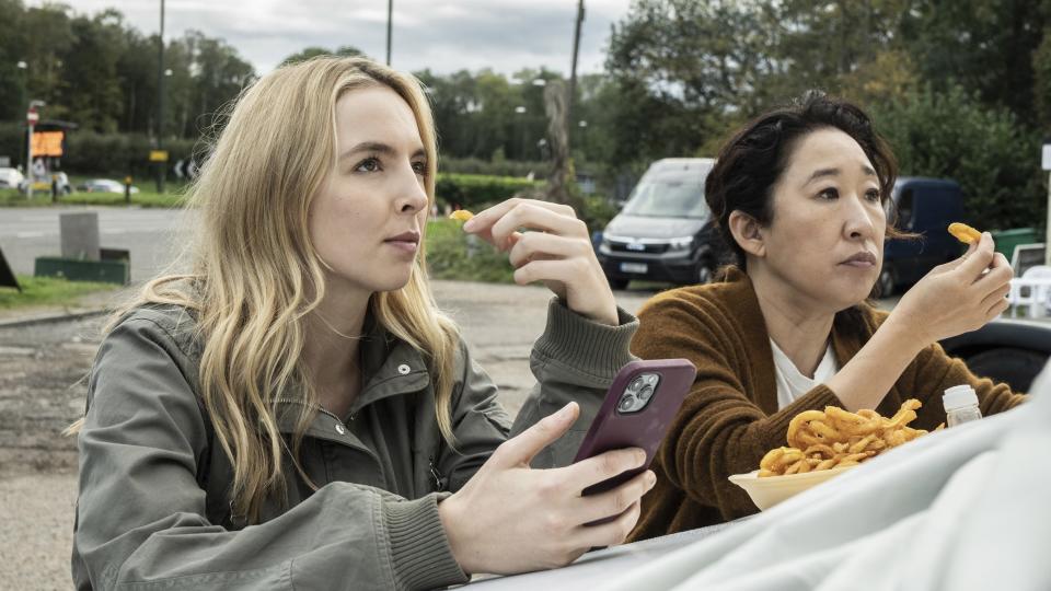 Villanelle and Eve eating onion rings in a park