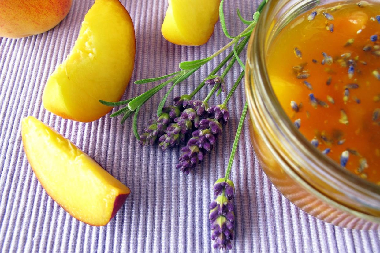 close-up of peach jam with lavender surrounded by peach slices and lavender flowers