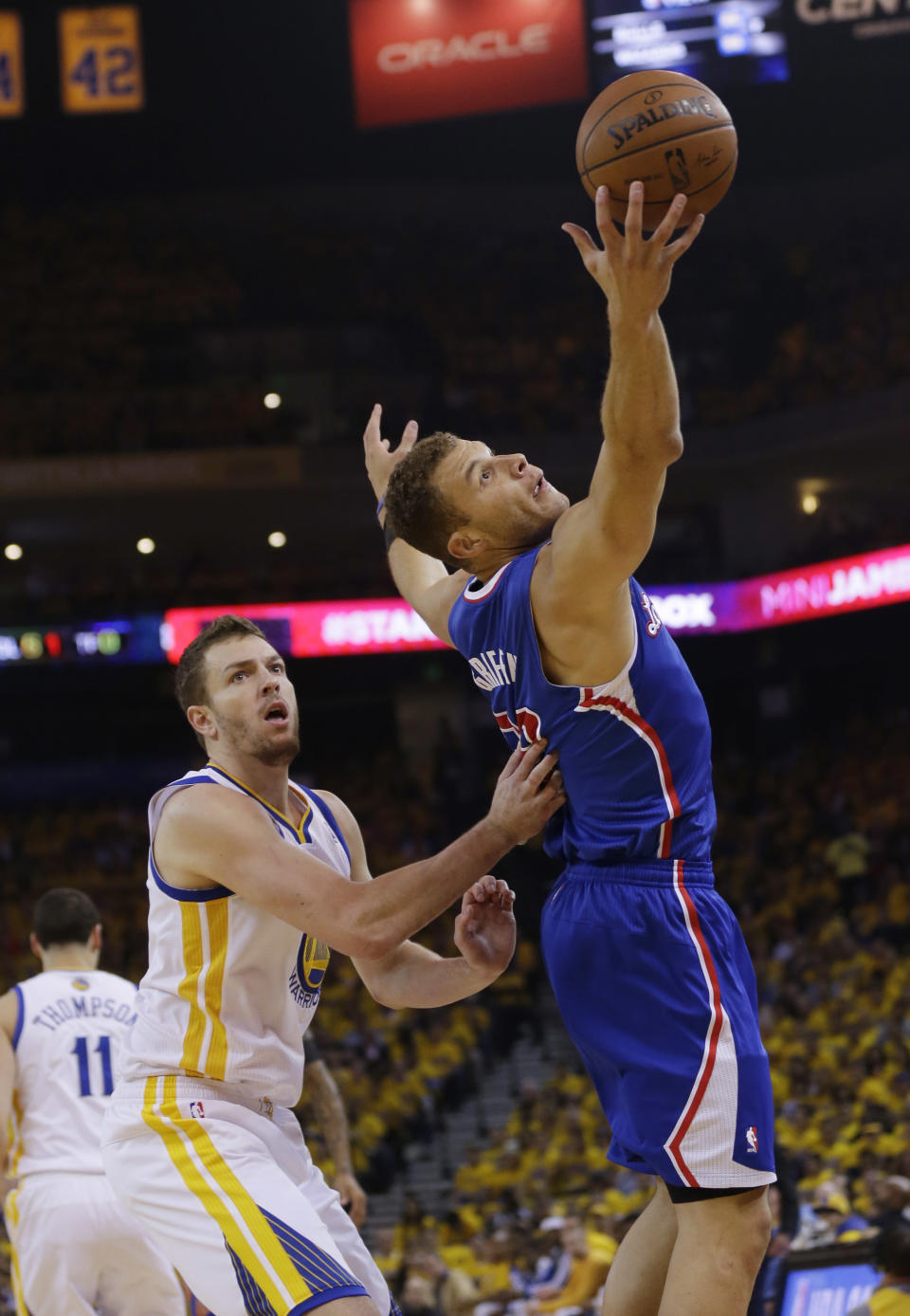 Los Angeles Clippers' Blake Griffin, right, grabs a high pass next to Golden State Warriors' David Lee during the first half in Game 4 of an opening-round NBA basketball playoff series on Sunday, April 27, 2014, in Oakland, Calif. (AP Photo/Marcio Jose Sanchez)