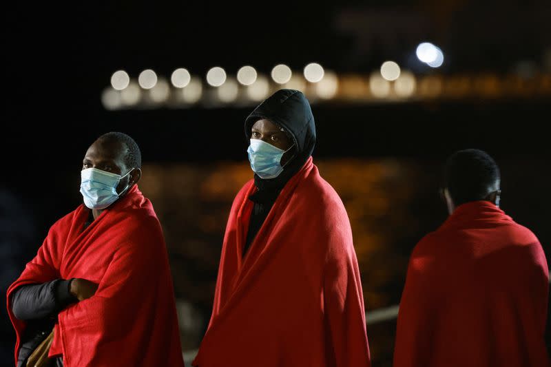 Migrants wait to disembark from a Spanish coast guard vessel, in the port of Arguineguin