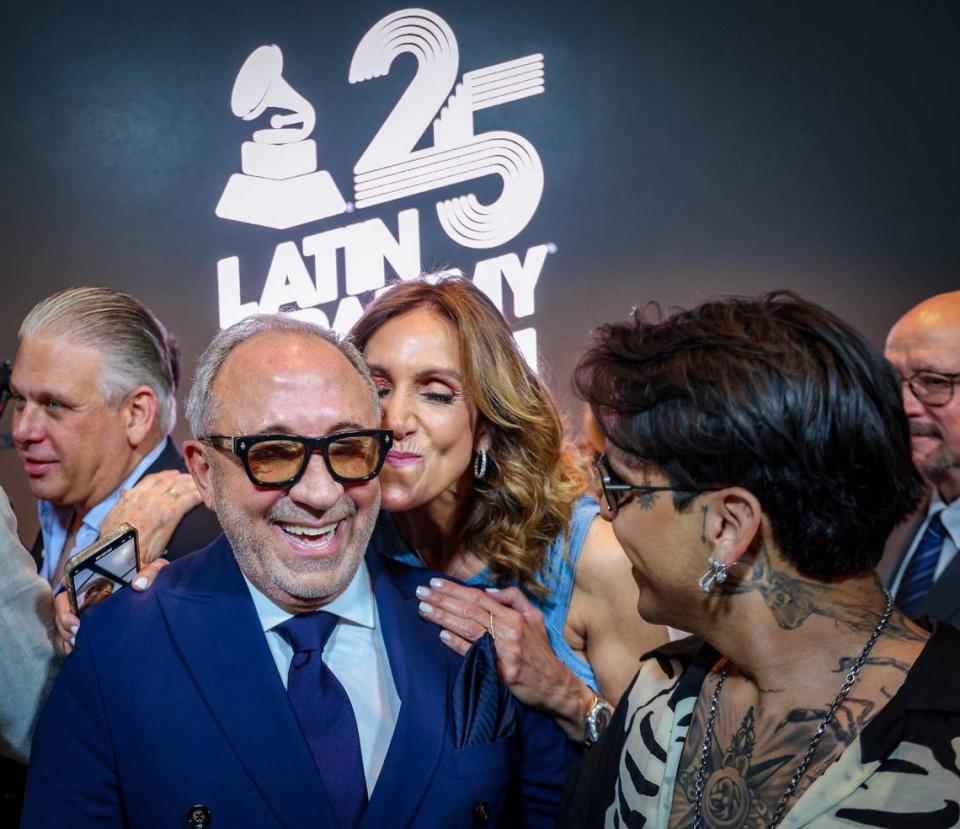 Music mogul Emilio Estefan, left, gets a kiss from his cousin, Lili Estefan, center, in celebration after Manuel Abud, CEO of the Latin Recording Academy, announced the Latin Grammy coming to Miami in November, 2024 during a press conference at the Kaseya Center in Miami, Florida on Wednesday, April 17, 2024. Carl Juste/cjuste@miamiherald.com