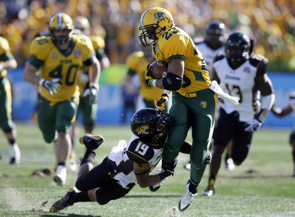 North Dakota State running back John Crockett (23) fights for extra yardage as Towson cornerback Juleon Killikelly-Lee (19) attempts the tackle in the first half of the FCS championship NCAA college football game, Saturday, Jan. 4, 2014, in Frisco, Texas. (AP Photo/Tony Gutierrez)