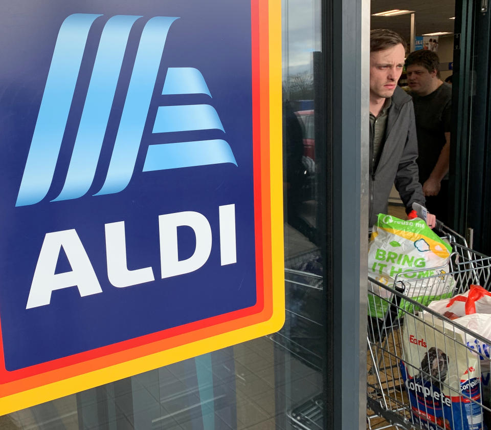 A man pushes a shopping trolley while leaving a Reuters store.