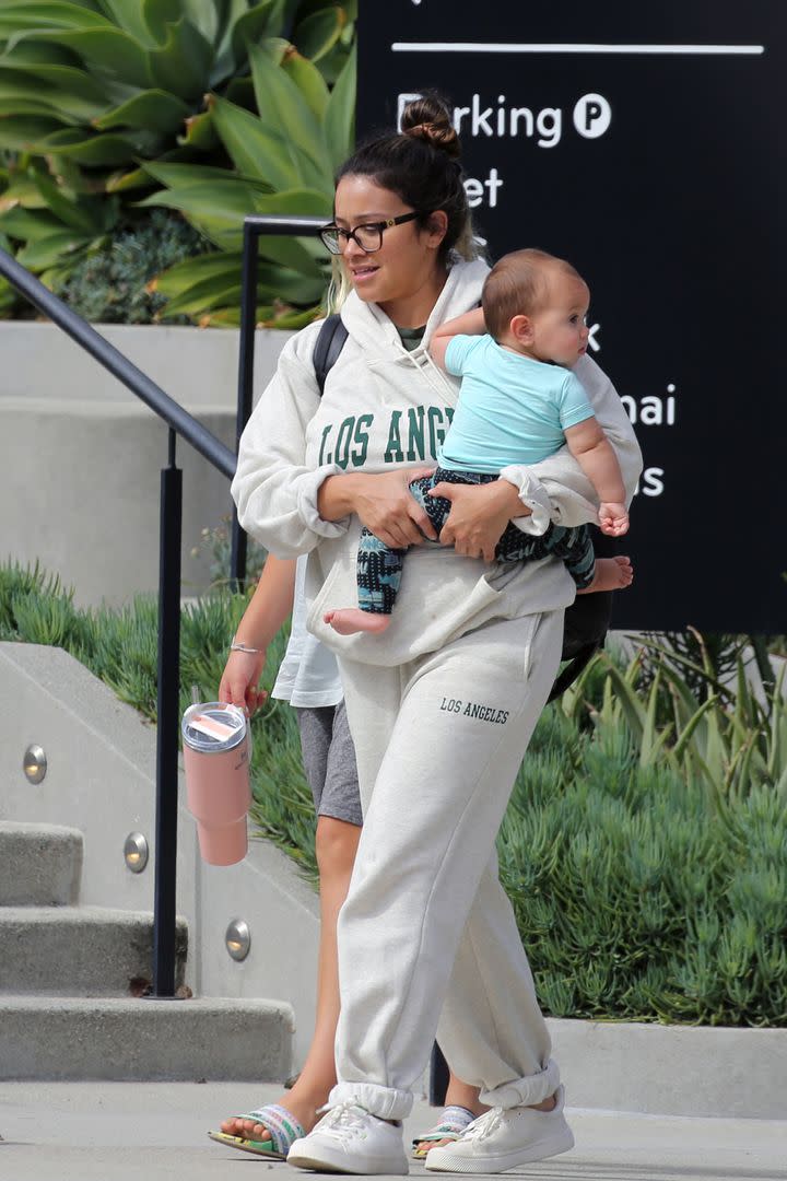 A diferencia de la modelo rusa, Gina Rodríguez fue descubierta con un look informal. La actriz estadounidense, que acaba de convertirse en madre, vestía un conjunto de jogging gris mientras caminaba con su hijo en brazos por Los Ángeles 