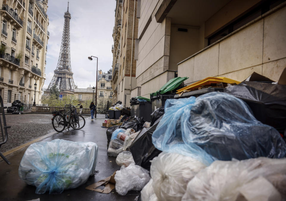 Uncollected garbage pile is on a street near Eiffel Tower in Paris, Friday, March 24, 2023. French President Macron's office says state visit by Britain's King Charles III is postponed amid mass strikes and protests. (AP Photo/Thomas Padilla)