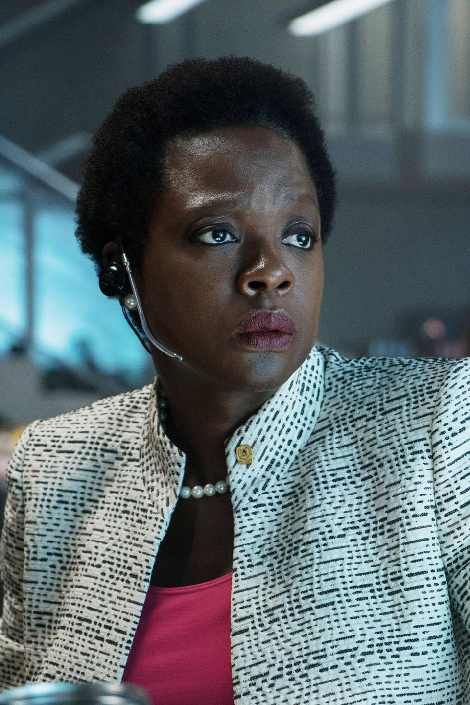 Viola in character wearing a tweed blazer and headset, looking intently at a computer screen