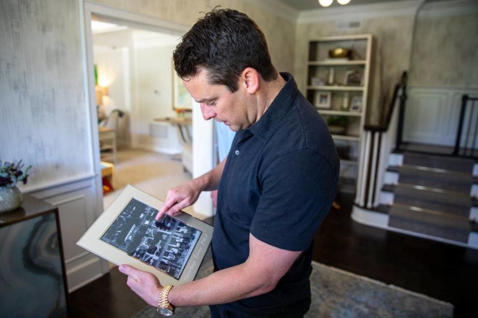 Brian Macho looks at an old aerial picture of his house and neighborhood in Myrtle Beach, S.C. His historic home, built on a shaded hill overlooking the “Golden Mile” in Myrtle Beach, is for sale for $2.5 Million. The 3609 square foot home was built in 1936 with and has been remodeled. April 24, 2024.