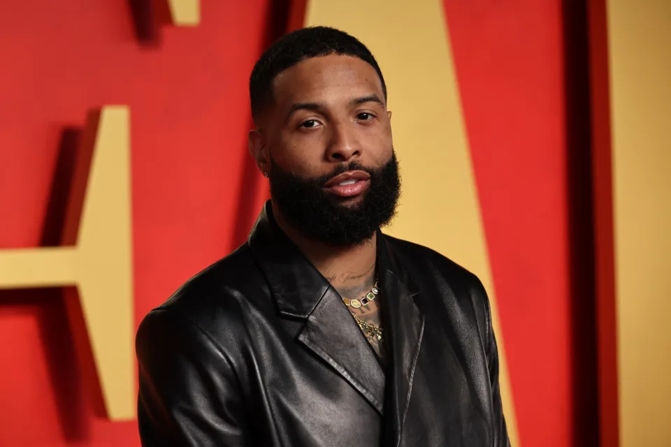 Odell Beckham Jr. poses on the red carpet wearing a sleek leather jacket