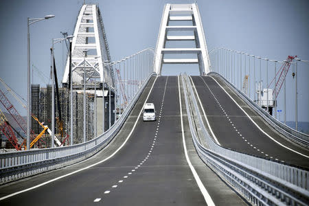 A vehicle drives along a bridge, which was constructed to connect the Russian mainland with the Crimean Peninsula across the Kerch Strait, May 15, 2018. Alexander Nemenov/Pool via REUTERS