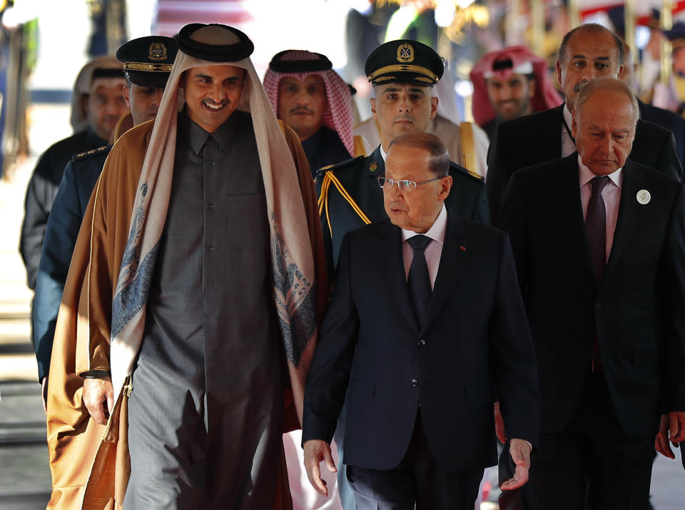 Lebanese President Michel Aoun, center, speaks with Qatar's Emir Sheikh Tamim bin Hamad Al Thani, left, upon his arrival at the Rafik Hariri international airport in Beirut, Lebanon, Sunday, Jan. 20, 2019. The ruler of the wealthy Gulf state of Qatar has arrived in Beirut to attend an Arab economic summit that has been marred by divisions over readmitting Syria to the Arab League. (AP Photo/Hussein Malla)