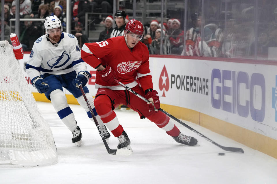 Detroit Red Wings left wing Elmer Soderblom (85) controls the puck next to Tampa Bay Lightning defenseman Nick Perbix (48) behind the net during the first period of an NHL hockey game, Wednesday, Dec. 21, 2022, in Detroit. (AP Photo/Carlos Osorio)