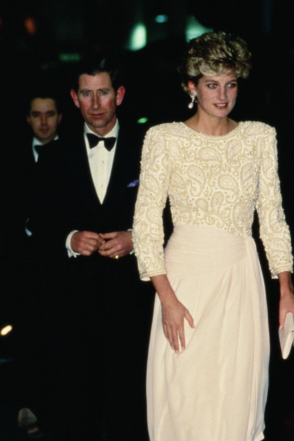 Princess Diana in elegant white gown and Prince Charles in black tuxedo at formal event
