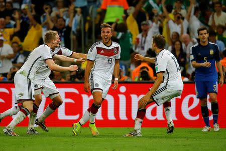 Germany's Mario Goetze (C) celebrates his goal against Argentina with his teammates (L-R) Andre Schuerrle , Benedikt Hoewedes and Thomas Mueller during extra time in their 2014 World Cup final at the Maracana stadium in Rio de Janeiro July 13, 2014. REUTERS/Kai Pfaffenbach